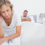 Unglückliches Paar sitzt nachdenklich im Bett