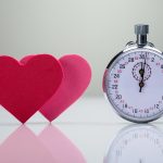 Zwei rote Herzen mit einer Stoppuhr - Speed-Dating