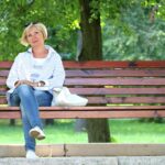 Frau sitzt alleine auf einer Bank