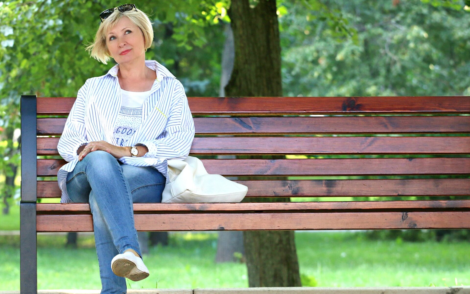 Frau sitzt alleine auf einer Bank