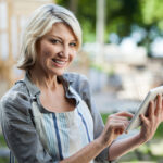 Ältere Dame mit Tablet beim online dating